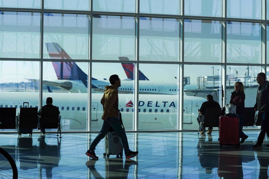 People travel through Hartsfield-Jackson Atlanta International Airport in Atlanta, Georgia, on Friday.