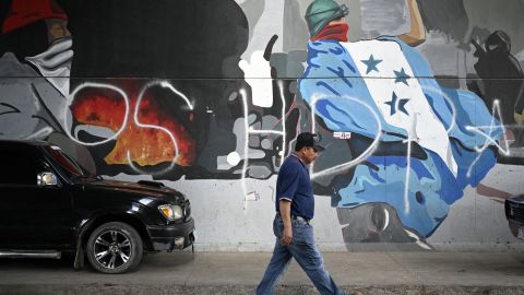 A man walks under a bridge at the Divino Paraiso neighborhood, in the north of Tegucigalpa, on November 11, 2025. With less than three weeks to go before the general elections, Honduras is experiencing a political crisis due to incessant accusations between the ruling left and the right-wing opposition of electoral fraud. (Photo by Orlando SIERRA / AFP) (Photo by ORLANDO SIERRA/AFP via Getty Images)          