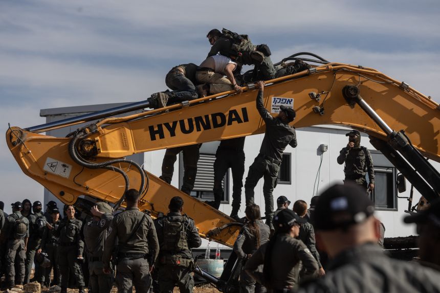 Israeli security forces clash with Hilltop Youth aboard the Earthmover as they evacuate and demolish an illegal outpost built near the Jewish settlement of Metzad.