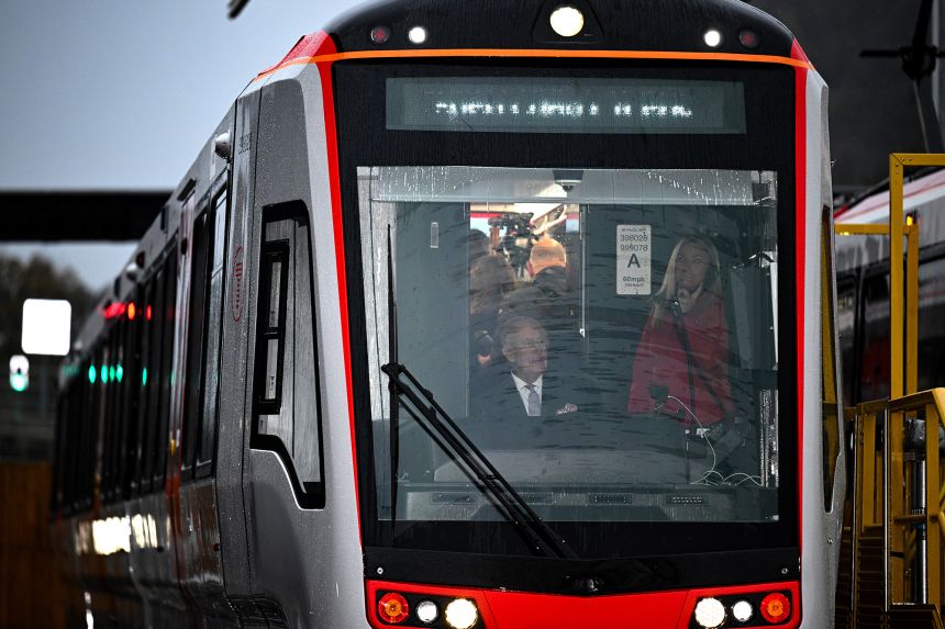Charles sat briefly in the driver's seat of a new tram at the South Wales Underground depot.