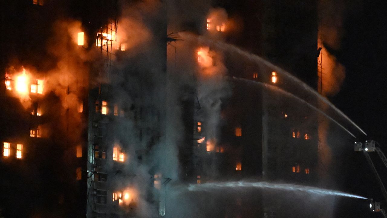Firefighters spray water during a major fire at the Wang Fuk Court residential estate in Hong Kong's Tai Po district on November 26, 2025. At least four people were killed when a fire engulfed several high-rise blocks in a Hong Kong residential estate on November 26, the government said, with media reporting that some residents were trapped inside.