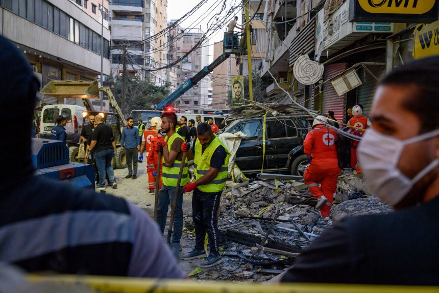 Hezbollah members and Lebanese army soldiers clear debris after a deadly Israeli attack on an apartment building in Beirut, Nov. 23.