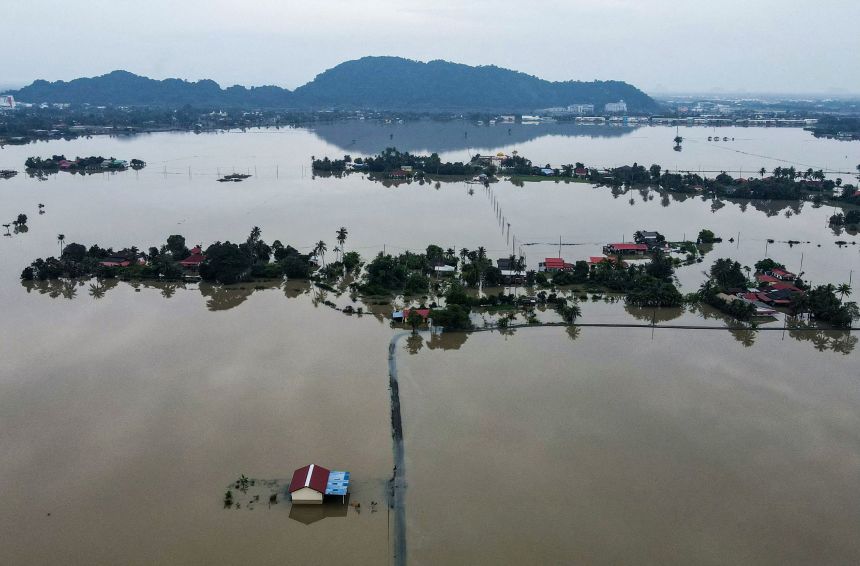 Homes were surrounded by flood waters in Kangar, part of Malaysia's Perlis state, on November 28, as severe flooding affected thousands of people in the region following days of heavy rain. (Photo by Mohd RASFAN / AFP via Getty Images)