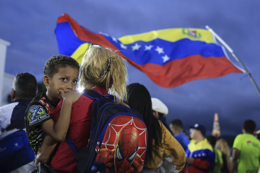 A child and his mother attend a military ceremony commemorating the 200th anniversary of the presentation of the 'Sword of Peru' to Venezuelan independence hero Simón Bolívar, in Caracas, Venezuela, on November 25, 2025.