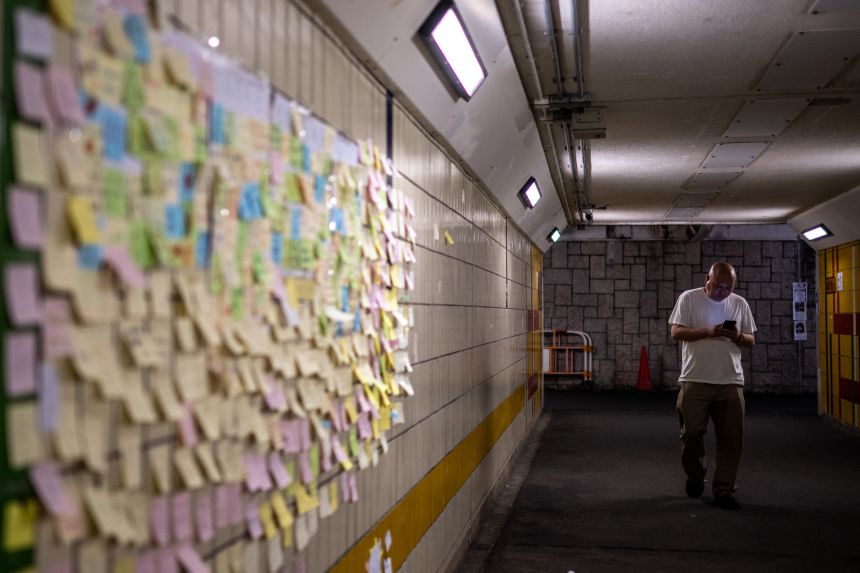 Handwritten notes left for the victims are seen on the wall of a pedestrian tunnel near the Wang Fuk Court apartment blocks.