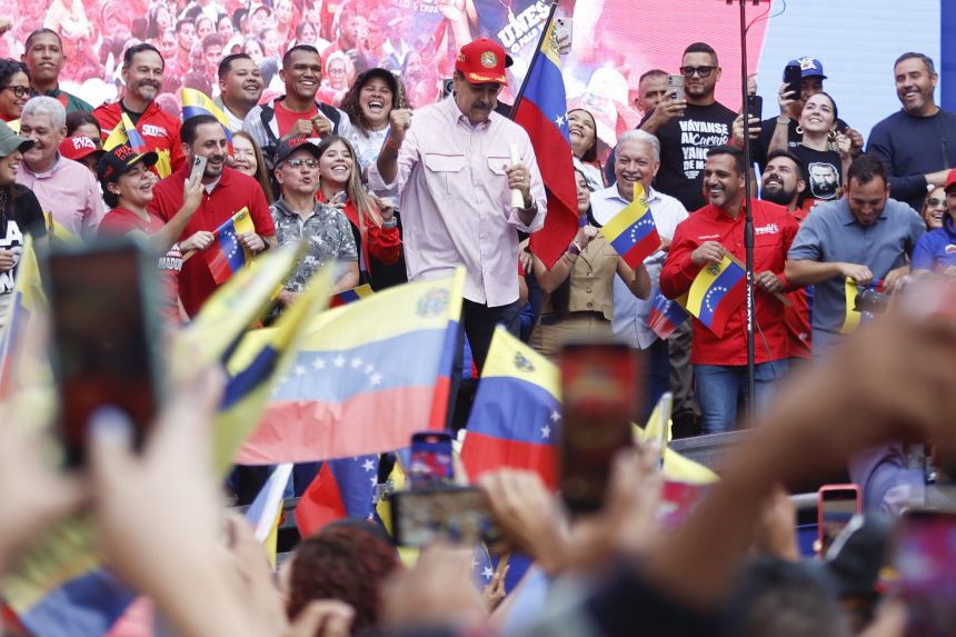 Venezuelan President Nicolas Maduro dances for his supporters during a rally in Caracas on December 1, 2025.