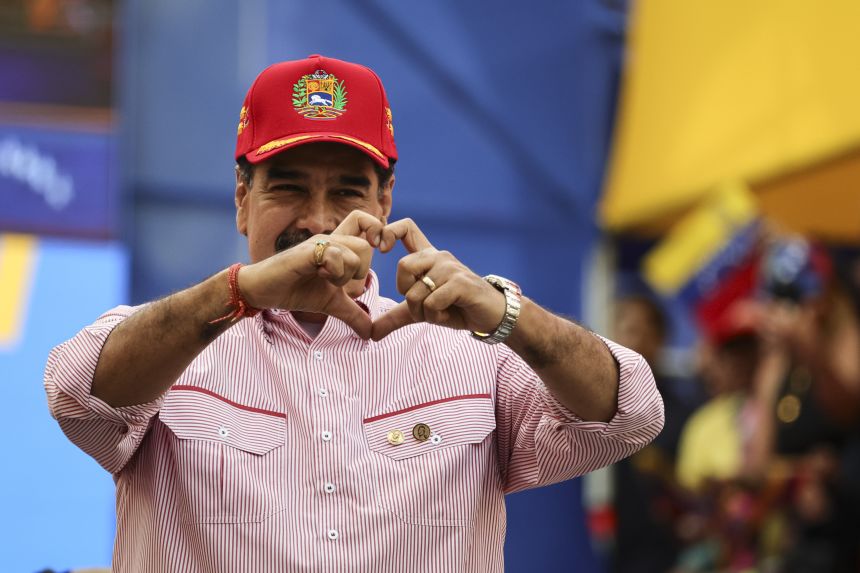 President Nicolas Maduro of Venezuela makes a heart with his hands during a rally in Caracas, Venezuela, on December 1, 2025.