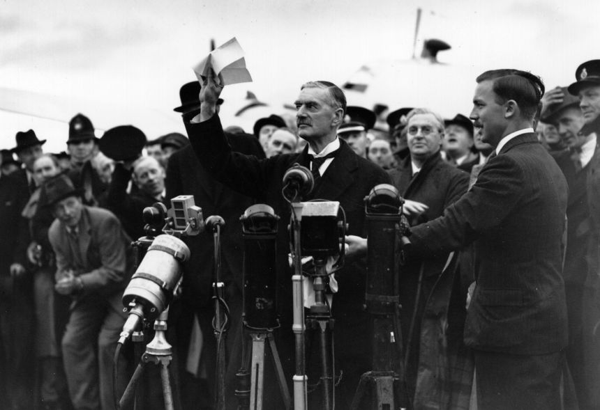 Former British Prime Minister Neville Chamberlain at Heston Airport after meeting with Hitler in Munich.