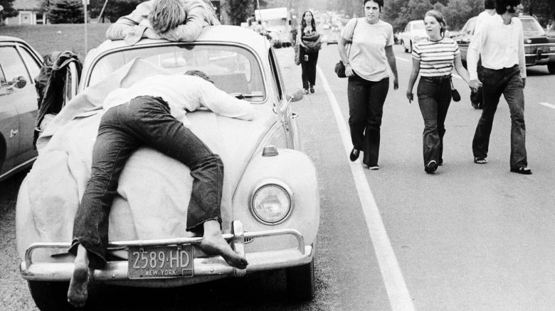 Two festival goers that found Woodstock too much lay passed out on the bonnet and roof of their Volkswagen Beetle. August 01, 1969. (Photo by Three Lions/Getty Images)