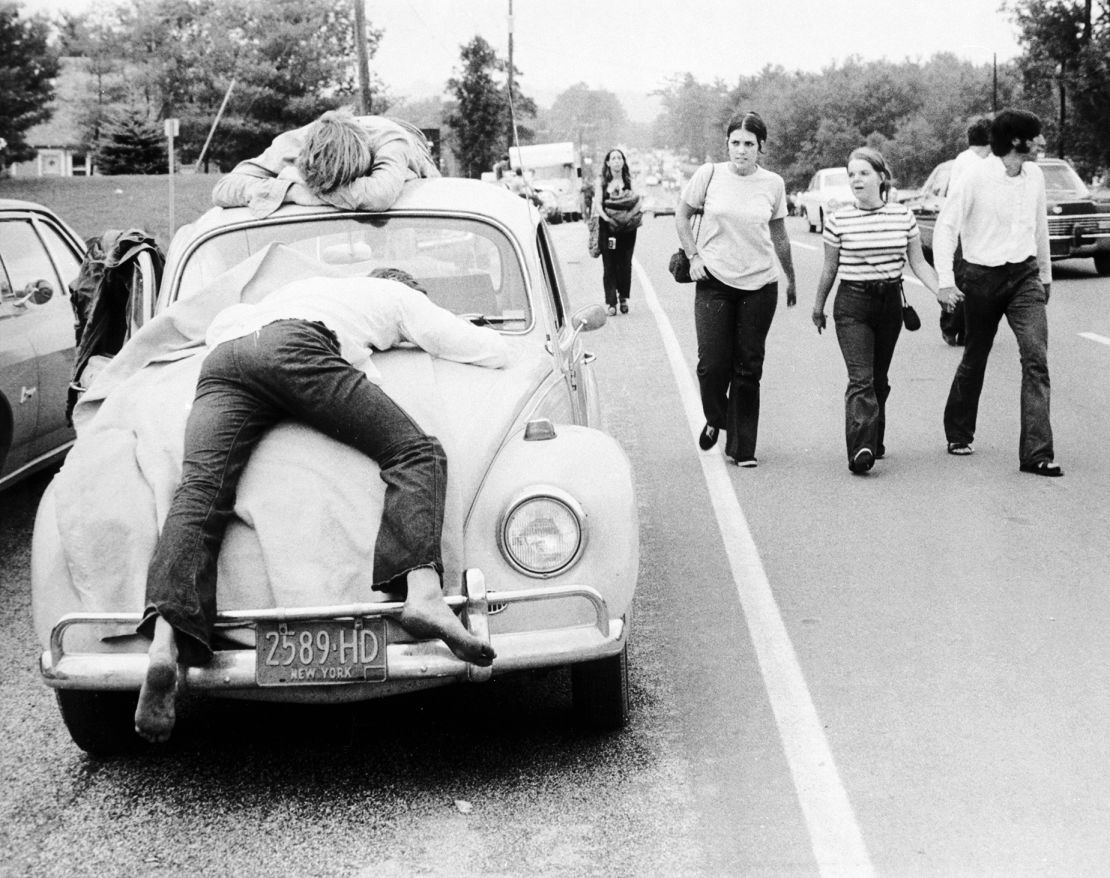 Dua pengunjung festival, yang menganggap Woodstock berlebihan, tergeletak di kap dan atap Volkswagen Beetle. 1 Agustus 1969.