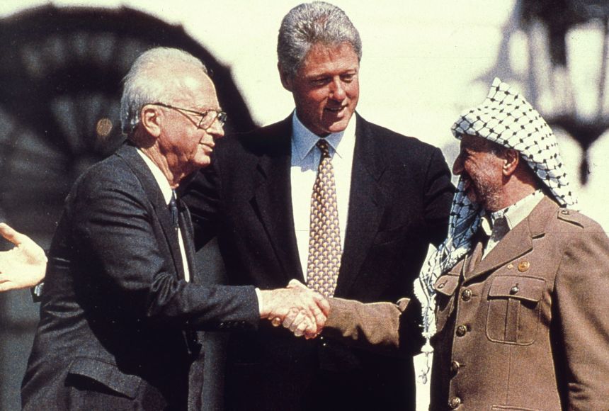American President Bill Clinton watches as the Israeli Prime Minister Yitzhak Rabin shakes hands with the Palestinian leader Yasser Arafat in the garden of the White House after the signing of the Oslo Accords on September 13, 1993.