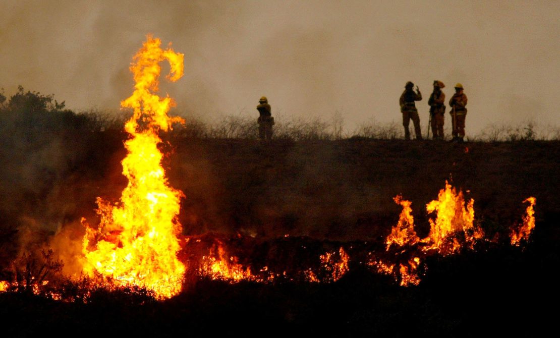 SAN DIEGO - OCTOBER 27: Firecrews light a controlled fire in an attempt to counteract the Cedar Fire October 27, 2003 near Lakeside in San Diego, California. The death toll stands at 13, with more than 1,000 homes being reduced to ashes as southern California fires continue to burn. Winds have eased a bit, but 30,000 homes remain threatened by the fires, which have charred more than 400,000 acres, according to officials. Davis, who has activated the National Guard, predicted damages will be in the billions of dollars. (Photo by Donald Miralle/Getty Images)