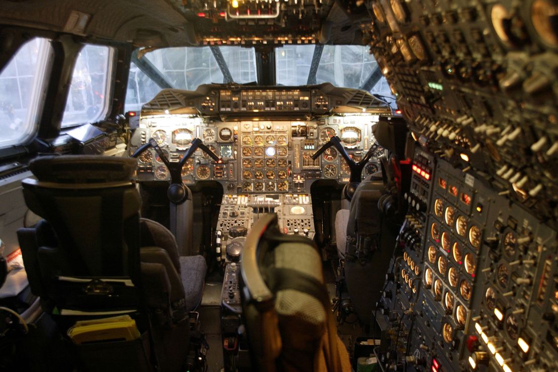 Inside a flight deck of a British Airways Concorde passenger jet. The flight engineer's large panel and moveable seat are on the right.