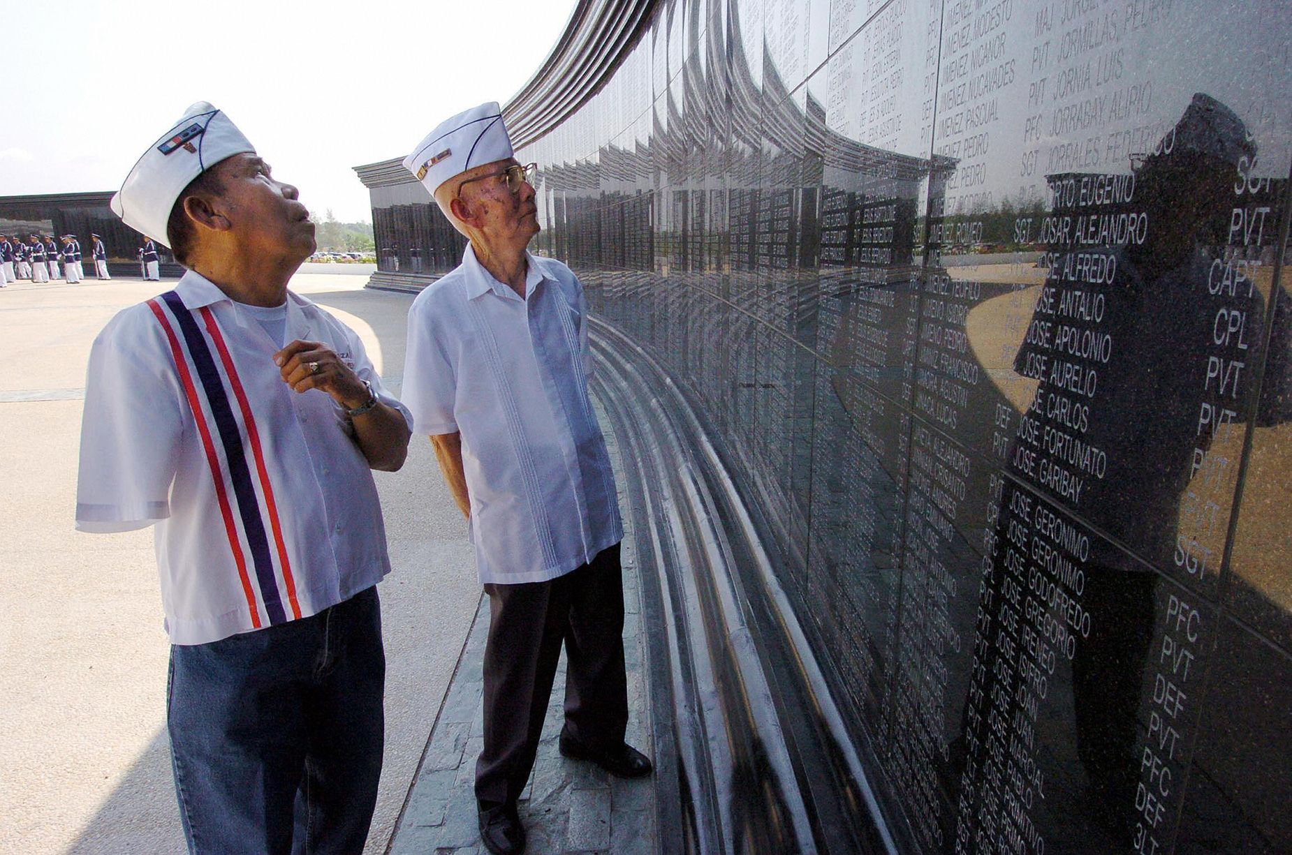 Disabled Filipino World War II veteran and death march survivor Manuel Abrazado, 80, (L) and his comrade Emilio Aquino, 86, (R) look at the names of their comrades at the Capas National Shrine in northern Tarlac province on April 6, 2004 during a memorial day marking the fall of Bataan. Romeo Gacad/AFP/Getty Images