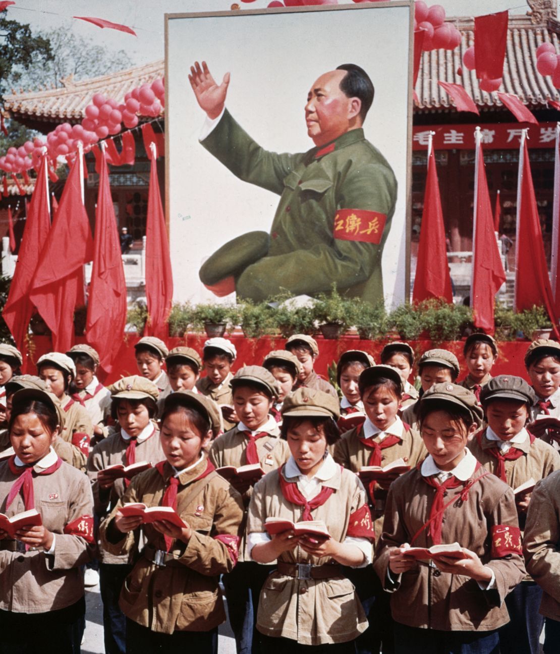 A group of children in uniform stood in front of a giant portrait of Chairman Mao Zedong, reading his 'Little Red Book' in 1968, during the height of the Cultural Revolution.