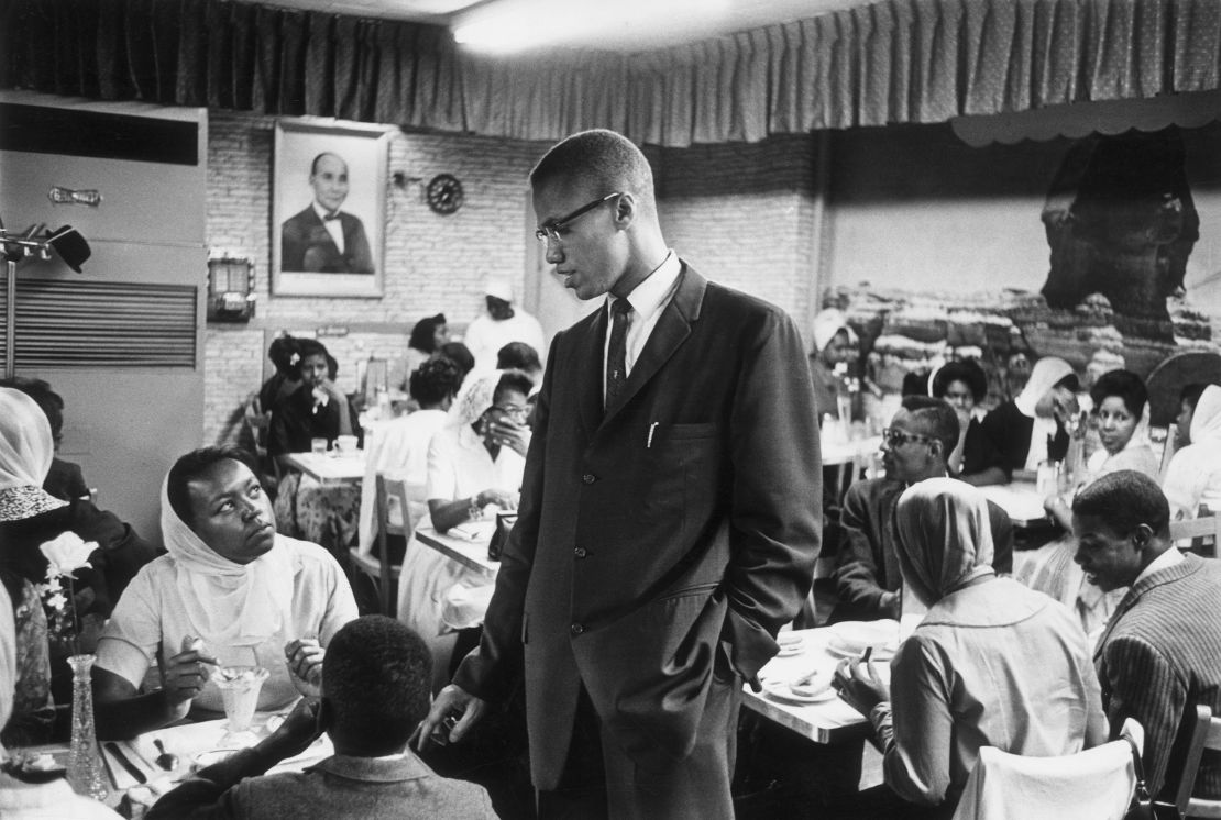 Malcolm X talks to a woman inside Temple 7, a Halal restaurant patronized by black Muslims, at Lenox Avenue and 116th Street in New York in 1965.