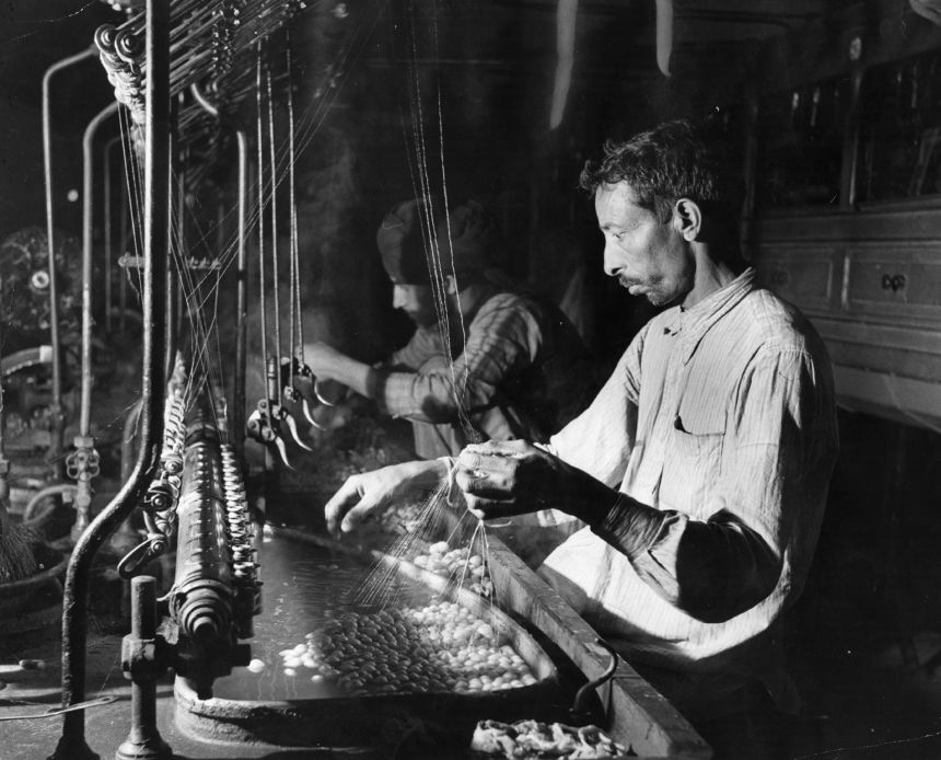 In a silk factory in Jammu, Kashmir in 1951, a local artisan simmers cocoons in hot water so the filaments may be unwound.
