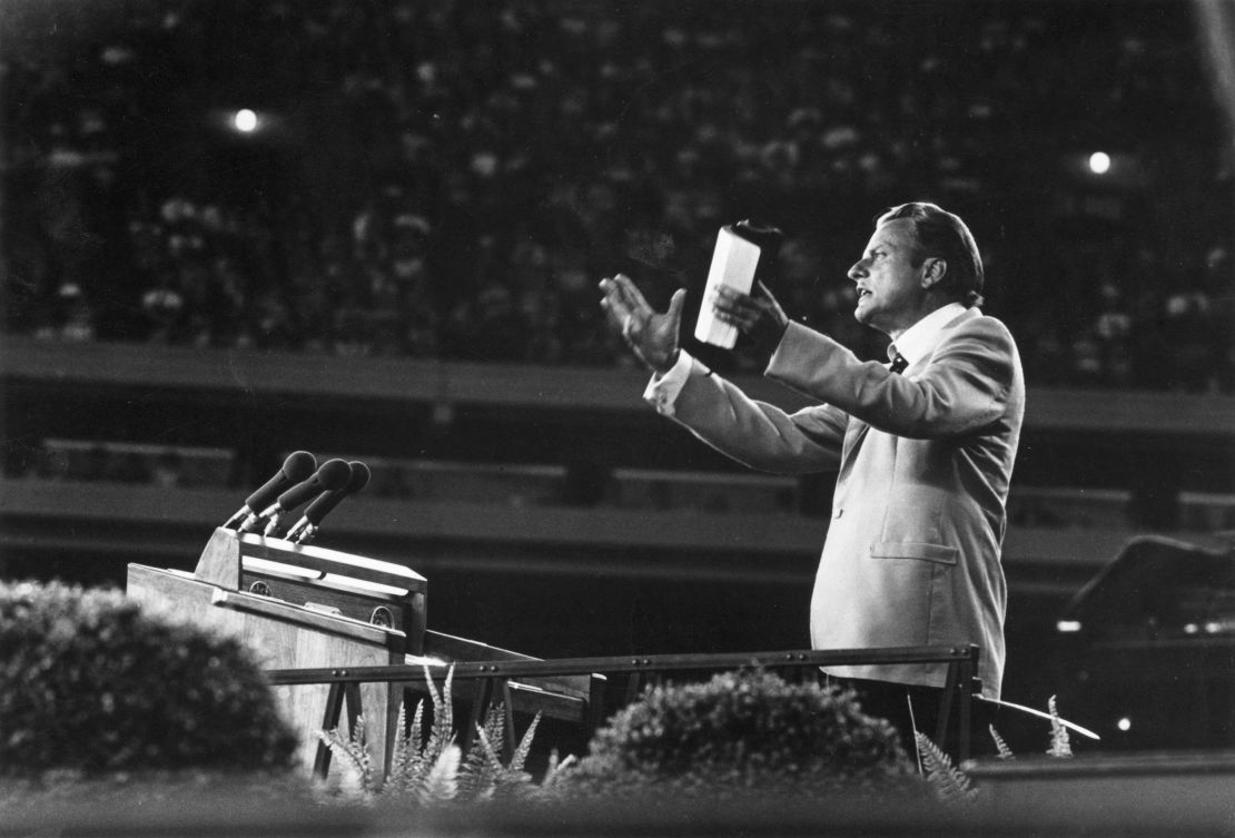 Evangelist Billy Graham speaking to a massive crowd in 1955.