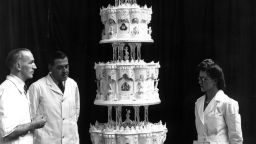 14th November 1947:  Mr Schur (centre), chief confectioner at McVitie and Price Ltd, standing next to the official cake for Princess Elizabeth's marriage to Philip Mountbatten which is nine feet tall.  (Photo by J. A. Hampton/Topical Press Agency/Getty Images)