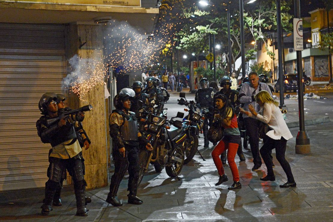 A policeman shoots tear gas at anti-government protesters during clashes in Caracas on June 12, 2014.
