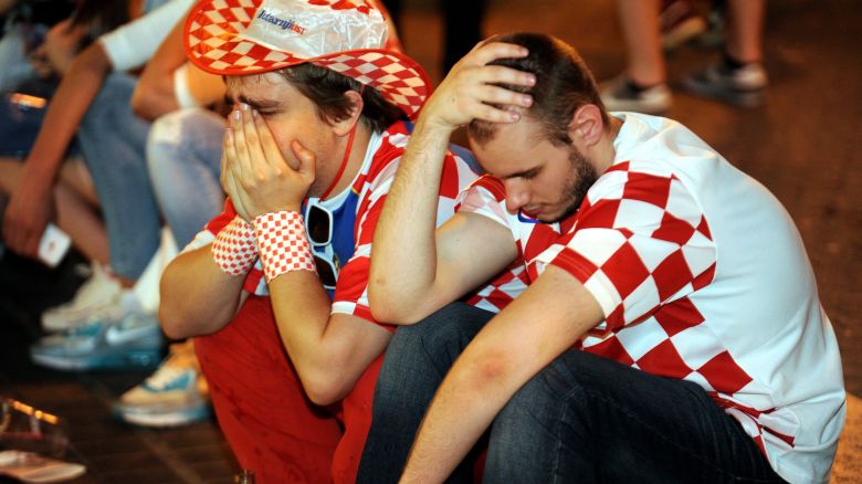 Croatian football fans react  June 23, 2014 in the Croatian capital Zagreb's main square after Croatia lost 1-3 in their 2014 FIFA World Cup group A football match against Mexico.  Several thousand people gathered at Zagreb's main square to watch the match between Mexico and Croatia on a giant screen.      AFP PHOTO / STR        (Photo credit should read STR/AFP via Getty Images)