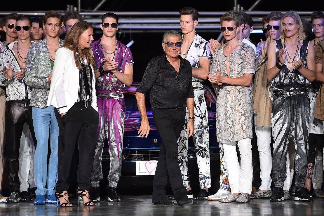 Flanked by models in quintessential Cavalli florals and animal prints, Roberto Cavalli takes his bow after his label's Spring-Summer 2015 menswear show at Milan Fashion Week on June 24, 2014.