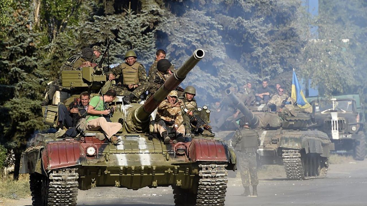 Ukrainian army soldiers ride a tank on a road near where pro-Russian separatists fired heavy artillery, on the outskirts of the key southeastern port city of Mariupol, on September 5, 2014. Ukraine and pro-Russian rebels agreed on September 5 on ceasefire aimed at halting nearly five months of war that plunged relations between Russia and the West into their worst crisis since the Cold War. AFP PHOTO/PHILIPPE DESMAZES        (Photo credit should read PHILIPPE DESMAZES/AFP via Getty Images)