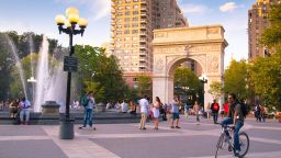 New York City, NY, USA - August 15, 2013: View of Washington Square Park in Manhattan with landmark arch and visitors present on a summer evening. Washington Square Park is a 9.75 acre park located in Greenwich Village and is a popular meeting spot.