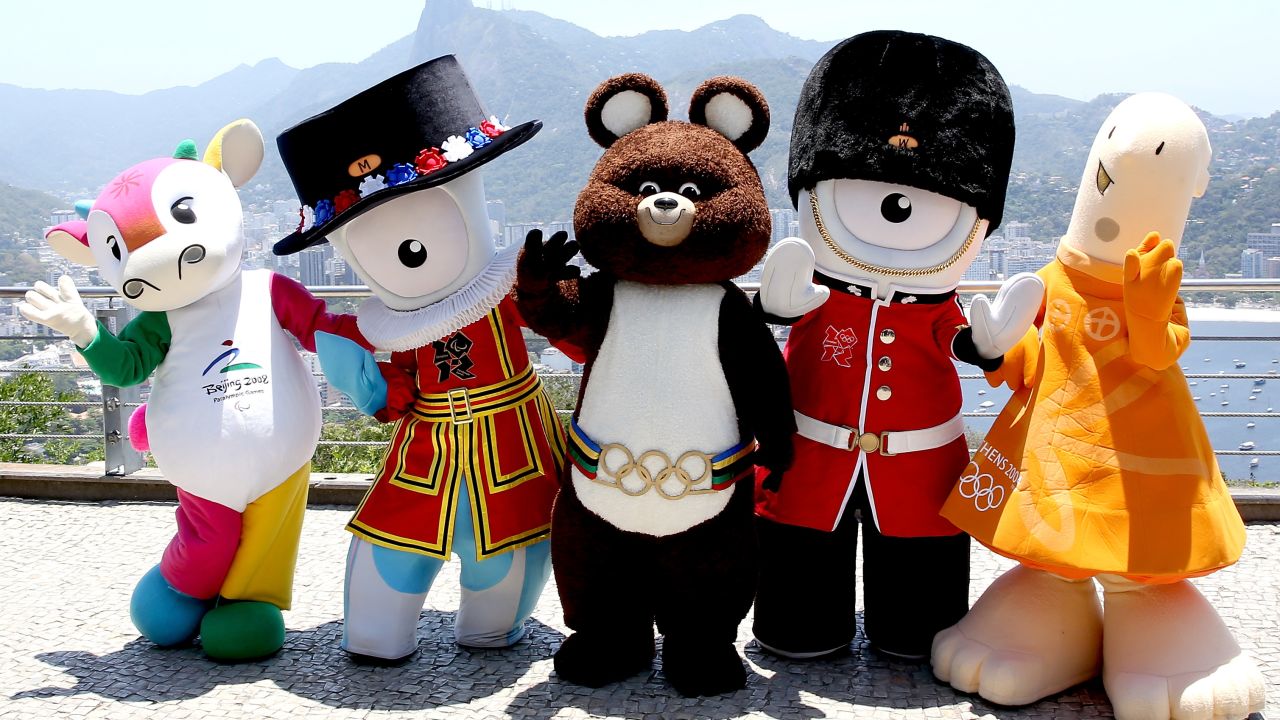 RIO DE JANEIRO, BRAZIL - NOVEMBER 21:  Fu Niu Lele, the mascot from the Beijing Olympic Games, Mandeville, the mascot from the London Olympic Games, Misha, the mascot from the Moscow Olympic Games, Wenlock, the mascot from the London Olympic Games and Athene, the mascot from the Athens Olympic Games, pose for a picture after meeting the children from the Vila Olímpica de Pedra de Guaratiba project atop Morro da Urca on November 21, 2014 in Rio de Janeiro, Brazil.  (Photo by Matthew Stockman/Getty Images)