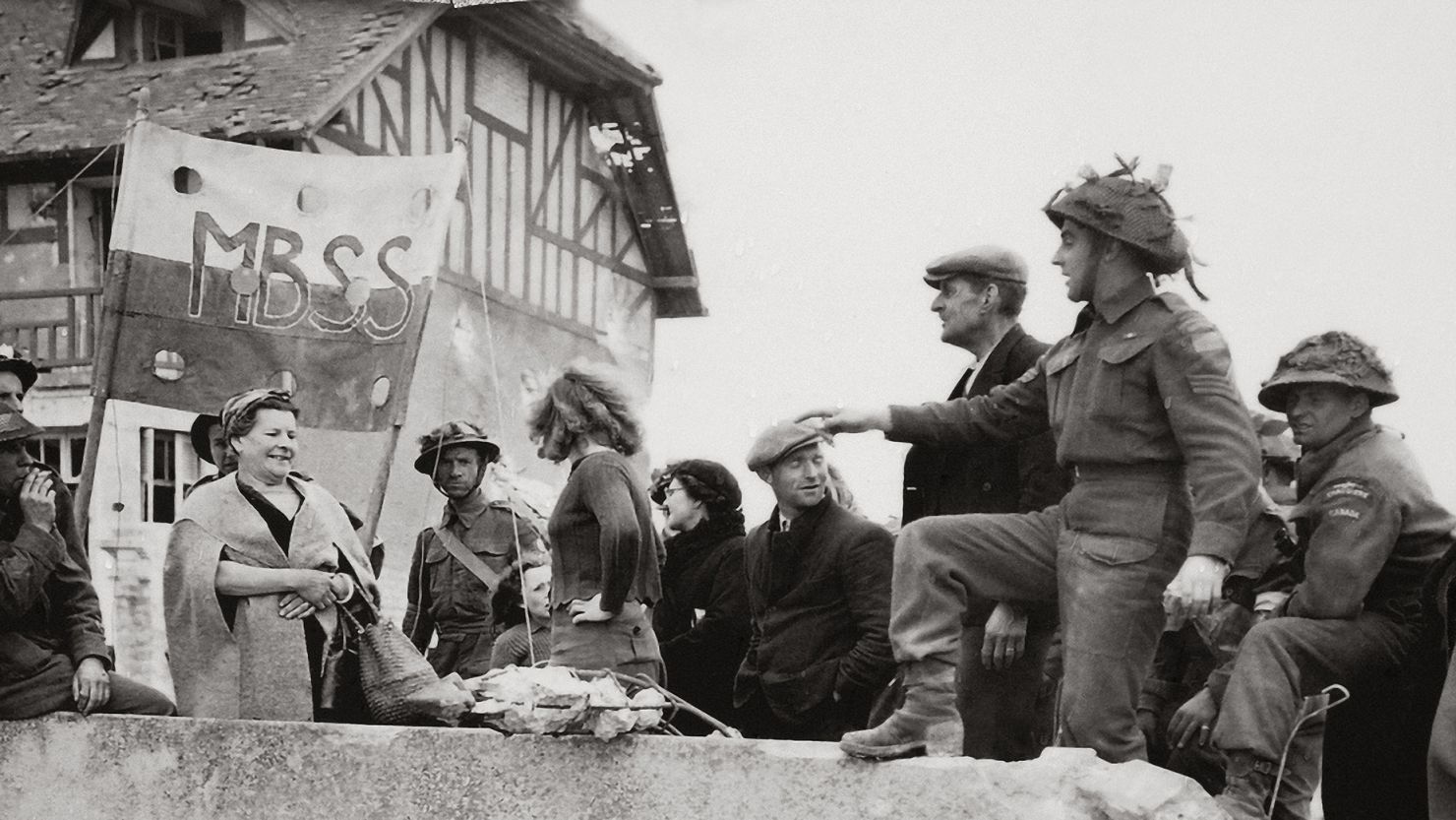 Canadian infantry soldiers and French civilians are seen after the landing at Juno Beach in front of the residence now known as "Canada House."