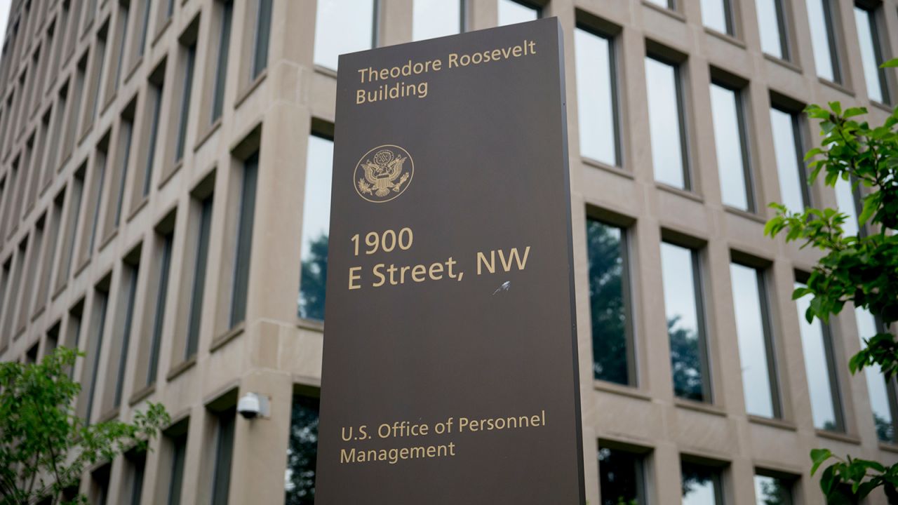 A sign stands outside of the Theodore Roosevelt Building, headquarters of the U.S. Office of Personnel Management (OPM), in Washington, D.C., U.S., on Friday, June 5, 2015.
