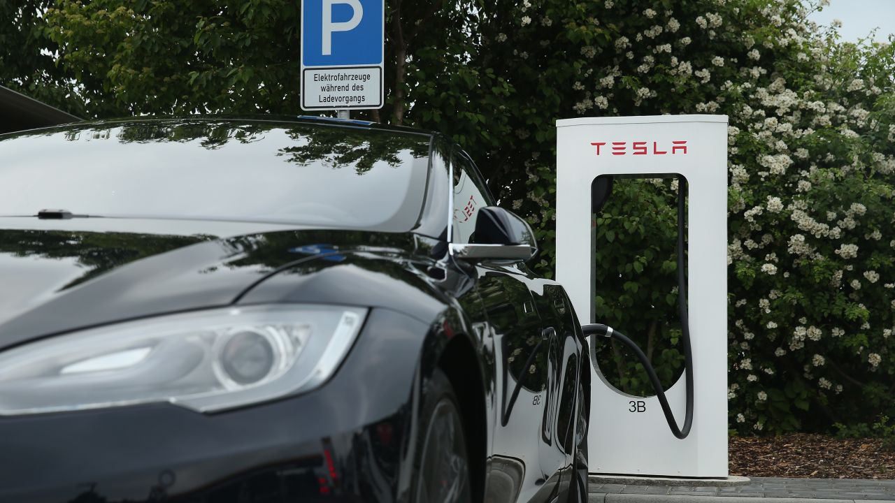 RIEDEN, - JUNE 11: A Tesla electric-powered sedan stands at a Tesla charging staiton at a highway reststop along the A7 highway on June 11, 2015 near Rieden, . Tesla has introduced a limited network of charging stations along the German highway grid in an effort to raise the viability for consumers to use the cars for longer journeys. (Photo by Sean Gallup/Getty Images)