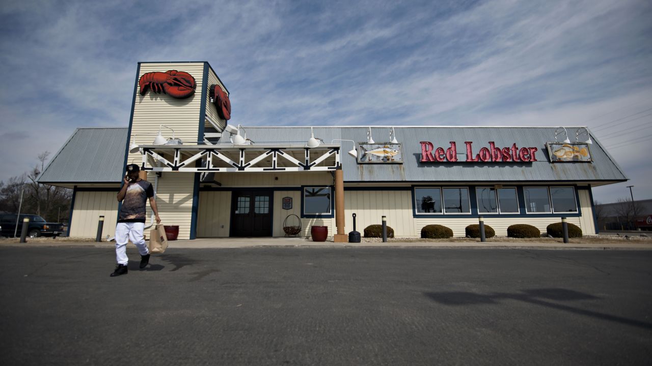 A customer talks on the phone while exiting a Darden Restaurants Inc. Red Lobster location in Peoria, Illinois, U.S., on Tuesday, March 18, 2014.