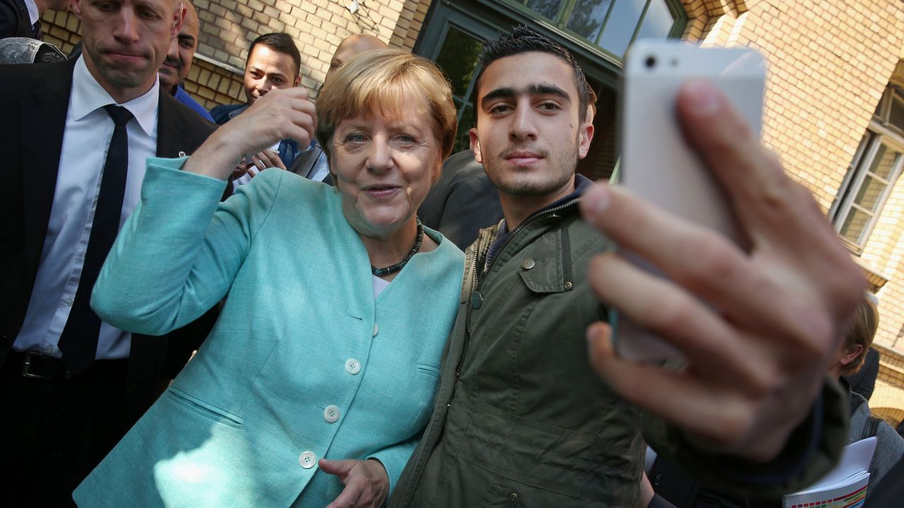 German Chancellor Angela Merkel poses for a selfie with Anas Modamani, a refugee from Syria, after she visited a shelter for migrants and refugees in Berlin, Germany, on September 10, 2015.
