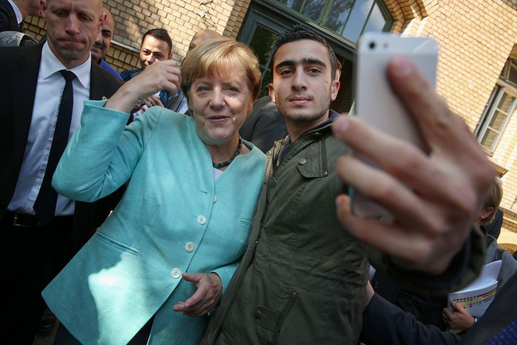 German Chancellor Angela Merkel poses for a selfie with Anas Modamani, a refugee from Syria, after she visited a shelter for migrants and refugees in Berlin, Germany, on September 10, 2015.
