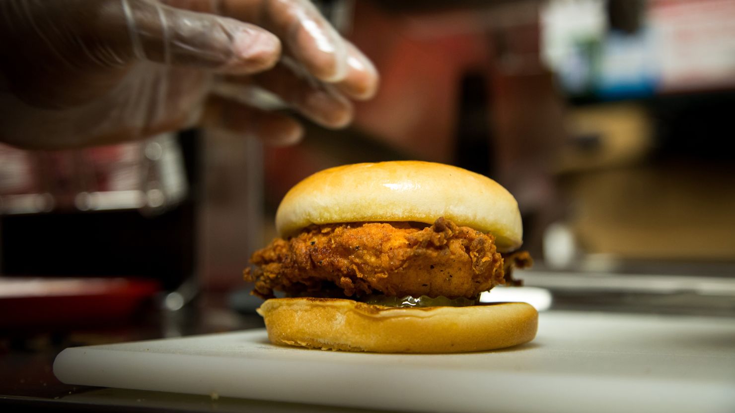 A employee picks up a fried chicken sandwich during an event ahead of the grand opening for a Chick-fil-A restaurant