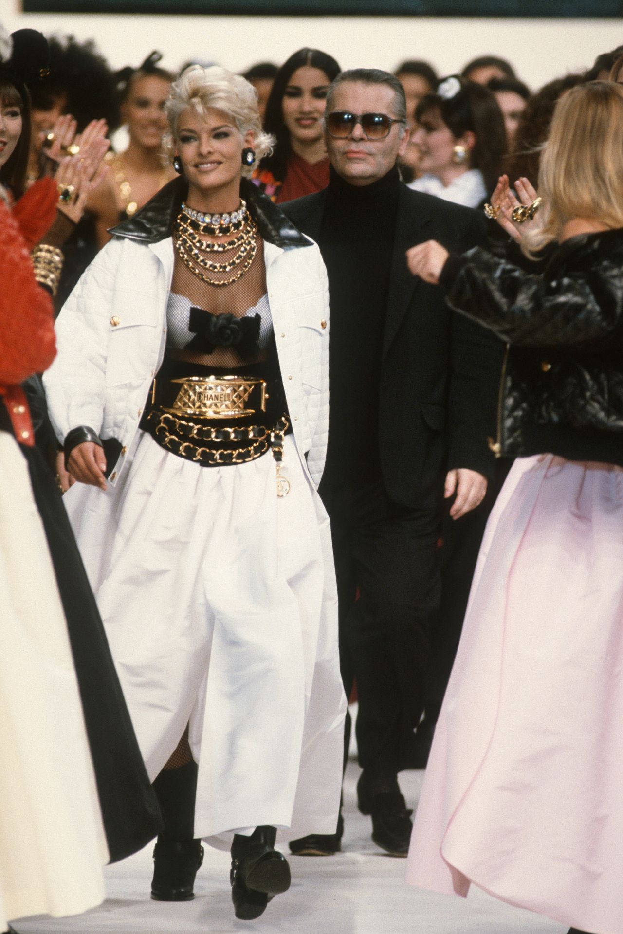 Linda Evangelista and Karl Lagerfeld (center) walk the runway during the finale of Chanel's 1991 Fall-Winter fashion show in Paris, France.