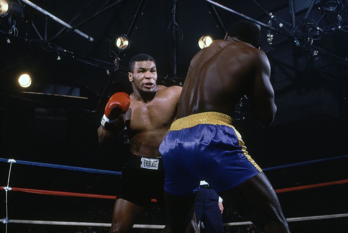 Tyson (left) entered the boxing world in 1985 as an 18-year-old. Here he is seen defeating Mark Young (right) at Latham Coliseum in his 15th professional fight.