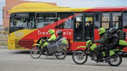 Riot police escort a bus during a protest at the "Transmilenio" station in southern Bogota, Colombia, on February 12, 2016. s of public transportation blocked roads to protest what they consider poor service and high cost. Amid the protest several buses were damaged as well as stations destroyed and several demonstrators were detained by police after clashes. AFP PHOTO / GUILLERMO LEGARIA / AFP / GUILLERMO LEGARIA        (Photo credit should read GUILLERMO LEGARIA/AFP via Getty Images)