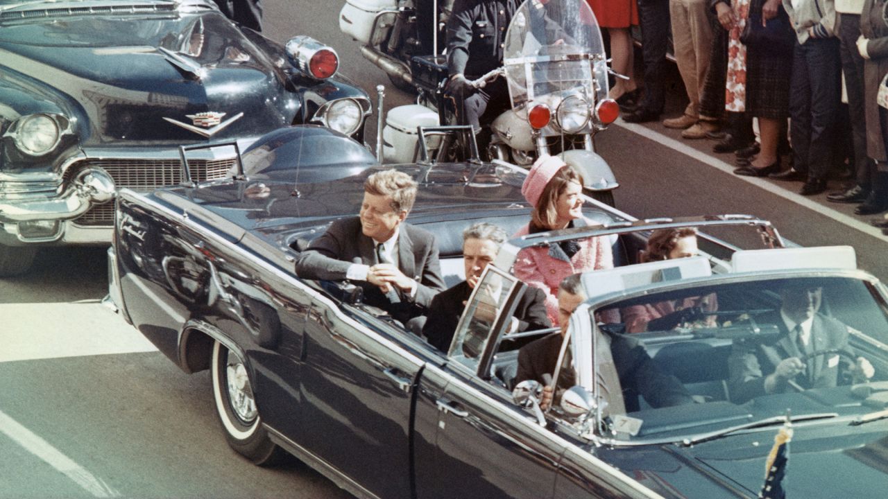 President John F Kennedy, first lady Jacqueline Kennedy, Texas Gov. John Connally and others smile at the crowds lining their motorcade route in Dallas, Texas, on November 22, 1963.