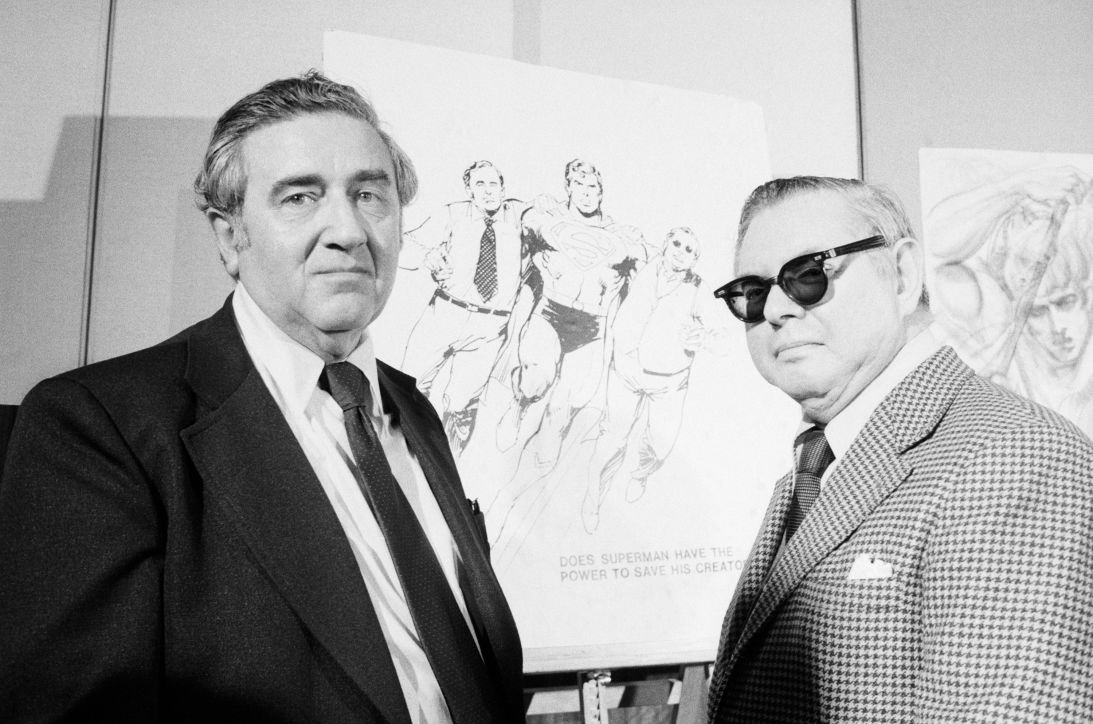 Superman creators Jerry Siegel, left, and Joe Shuster pose in front of sketches of their creation.