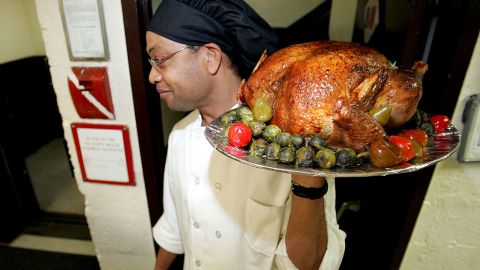 NEW YORK - NOVEMBER 23: Assistant Chef Joe Breaton carries out a turkey prior to actor Stephen Baldwin serving Thanksgiving dinner to men and women at the New York City Rescue Mission on November 23, 2004 in New York City. (Photo by Paul Hawthorne/Getty Images)