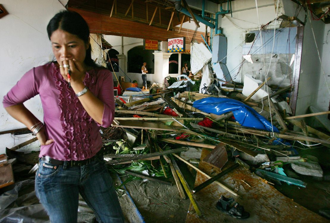 A Thai woman walks by the devastation at a hotel along Patong Beach, one of the worst tsunami-hit provinces, on December 27, 2004, in Phuket, Thailand. The Boxing Day tsunami triggered by a massive underwater quake in the Indian Ocean killed at least 225,000 people.