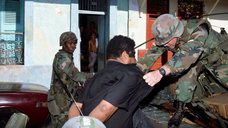 American soldiers detain a man caught looting during the invasion of Panama in 1989.