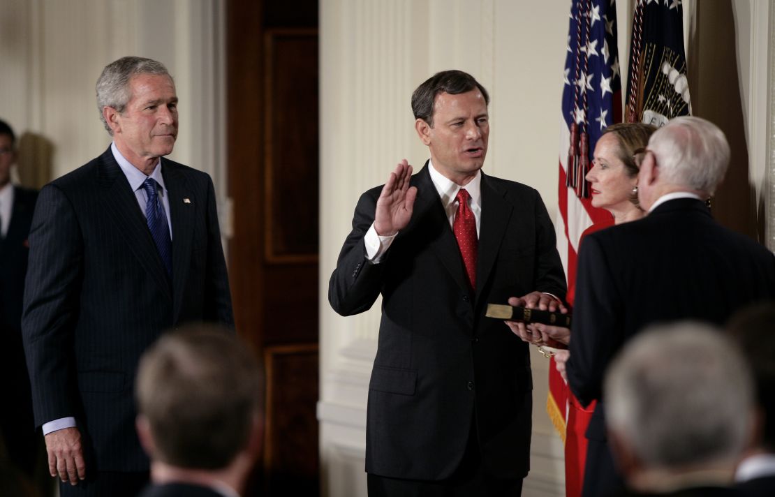 Judge John Roberts, center, is sworn in as the 17th Chief Justice of the United States by Associate Supreme Court Justice John Paul Stevens, right, with President George W. Bush, left, at his side in Washington, DC, on September 29, 2005.