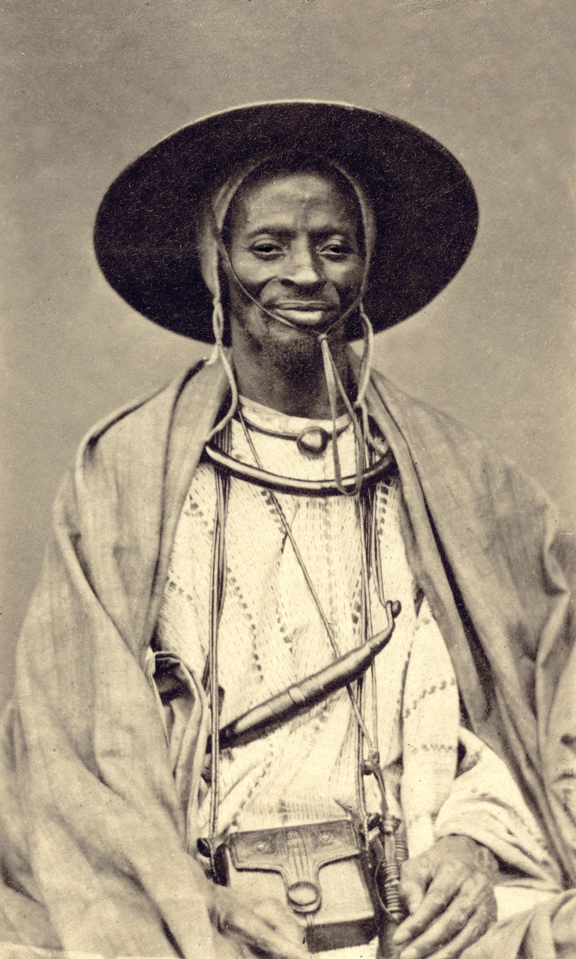 From the mid-19th century, elite Senegalese commissioned photograph portraits, such this one, a copy of which was handed to Belgian explorer Adolphe Burdo in 1878, by a man Burdo called the 'King of Dakar.' The modernity shown by this African shocked Burdo so much that he quickly left the city, writes Paoletti.