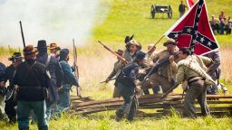 Confederate reenactors breach a Union barricade during a staging of Battle of Gettysburg.