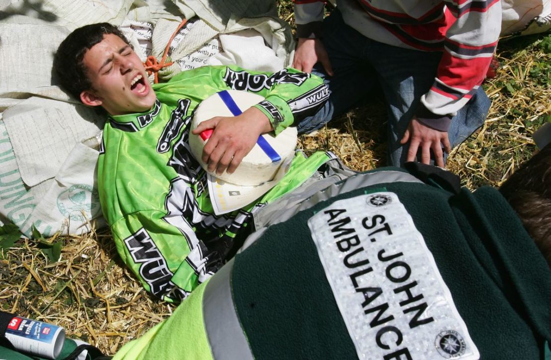 Chris Anderson sostiene su queso mientras recibe atención médica tras una carrera en 2005. Ganó, pero sufrió una fractura de tobillo.