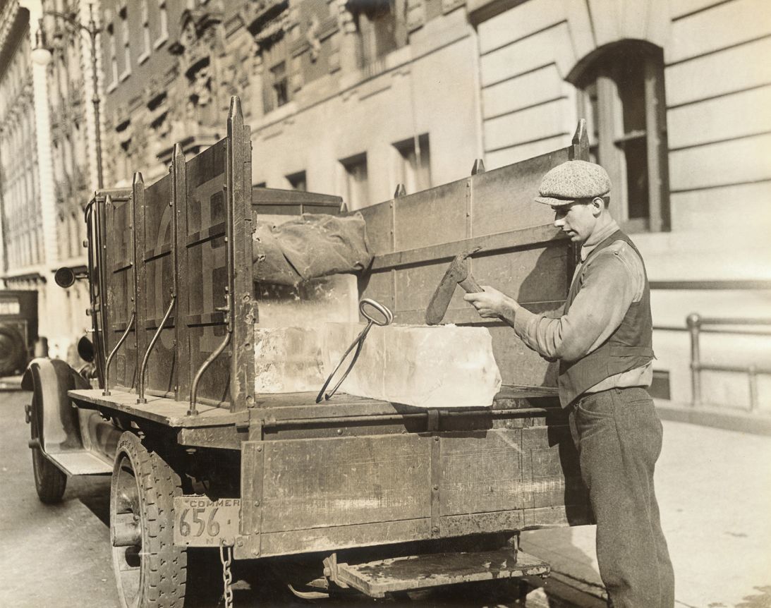 Ice became a status symbol in the US in the 19th and 20th centuries. Pictued here, chopping off an ice piece for a home ice box — a precursor to a fridge — circa 1920.