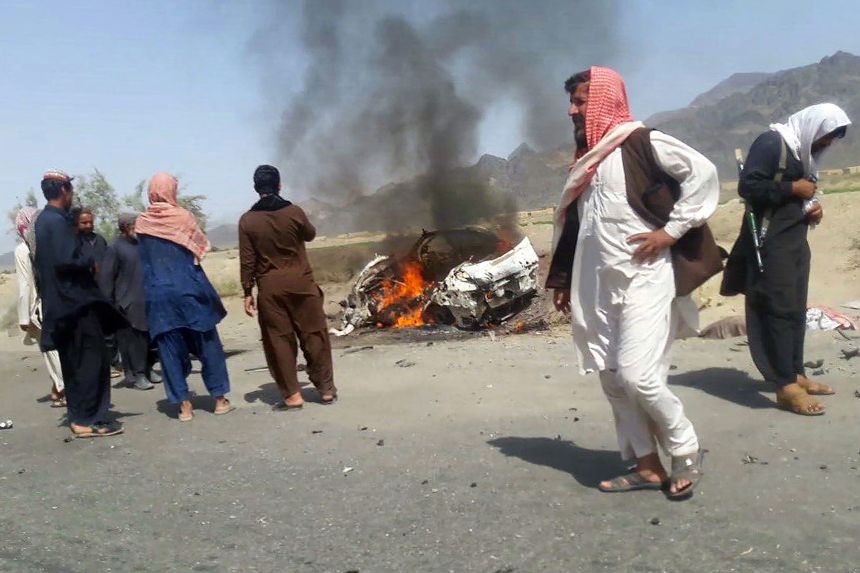 Pakistani locals gather around a destroyed vehicle hit by a drone strike, in which an Afghan Taliban chief was believed to be traveling, in the remote town of Ahmad Wal in Balochistan, Pakistan, in May 2016.